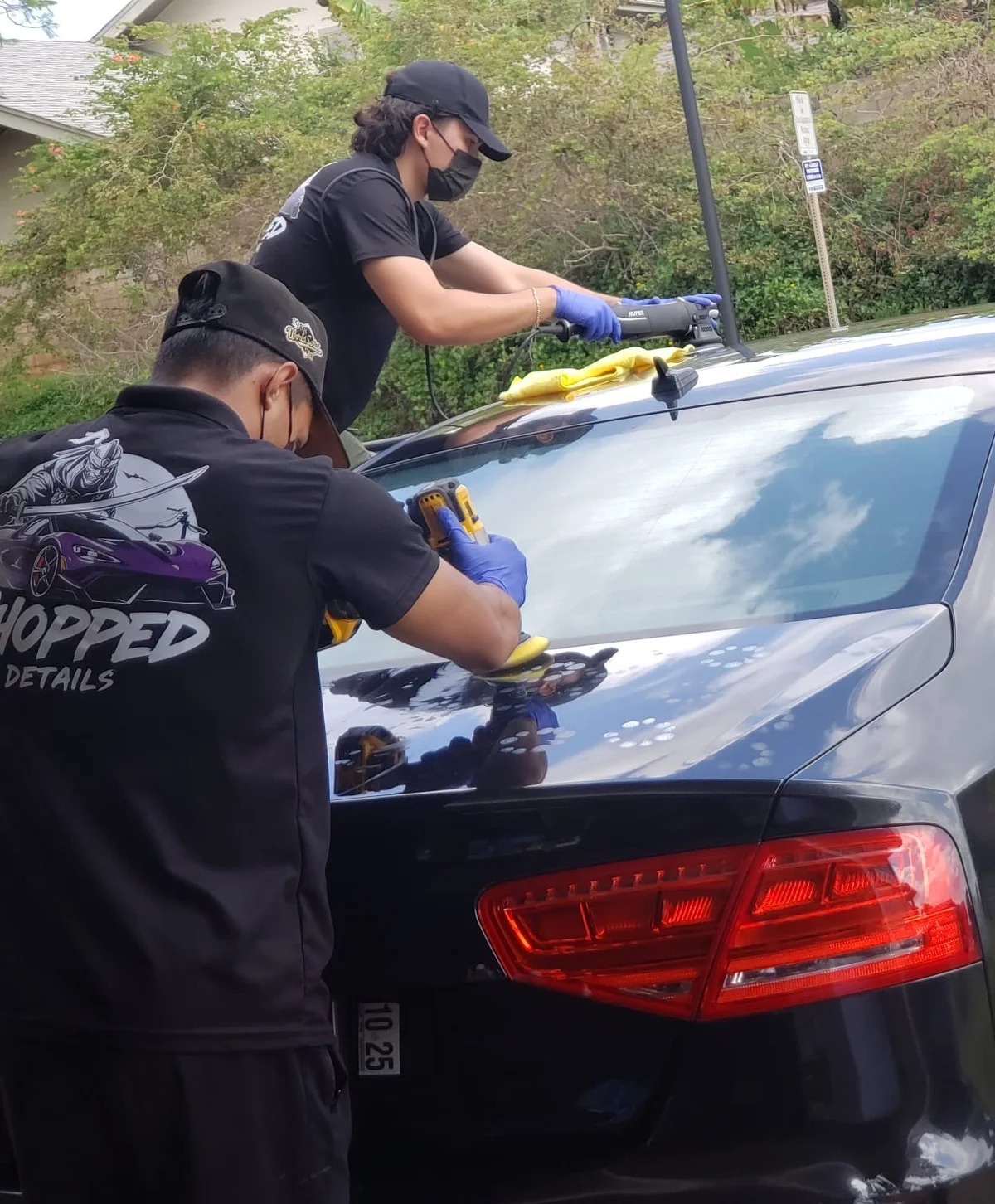 Chopped Details technicians machine-polishing a hazy, unfinished trunk lid on a black Audi S8